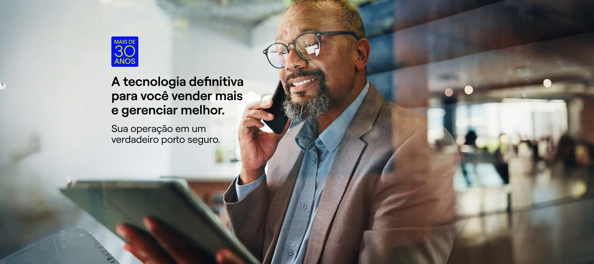 Corretor sorrindo com tablet: a tecnologia definitiva para você vender mais e gerenciar melhor, nidotec
